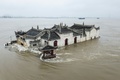 中国中部の湖北省武漢で、長江の増水により浸水した、700年前に岩の上に建てられた寺院「観音閣」（2020年7月20日撮影）。(c)STR / AFP