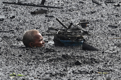 マニラ湾口近くの無認可居住地で火災、潮水に漬かる住民 フィリピン