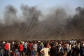 パレスチナ自治区のガザ市東部にあるイスラエルとの境界沿いで起きた衝突で、イスラエル軍が放った催涙ガス弾を見るデモ参加者（2018年9月28日撮影）。(c)SAID KHATIB / AFP