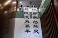 中国・香港の立法会で、林鄭月娥（キャリー・ラム）行政長官を批判する垂れ幕を掲げる民主派の林卓廷議員（2020年11月12日撮影）。(c)Anthony WALLACE / AFP