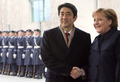 写真はベルリンで同日、公式歓迎式典で安倍首相と握手を交わすメルケル首相。(c)AFP/DDP/MARCUS BRANDT