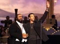 1999年6月1日、モデナ（Modena）で開催されたコンサート「パバロッティと仲間たち（Pavarotti and Friends）」で、ライオネル・リッチー（Lionel Richie、右）とともに観客の声援に応えるルチアーノ・パバロッティ（Luciano Pavarotti、左）。(c)AFP