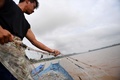 タイ・チェンライのメコン川で漁をするコム・ウィライさん（2019年9月20日撮影）。(c)Lillian SUWANRUMPHA / AFP