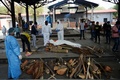 インドの首都ニューデリーにある火葬場で、コロナ犠牲者の遺体を運ぶ防護服姿の作業員（2020年6月3日撮影）。(c)AFP/Sajjad  HUSSAIN