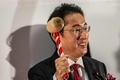東京証券取引所で行われた大納会で、鐘を鳴らす準備をする岸田文雄首相（2022年12月30日撮影）。(c)Philip FONG / AFP
