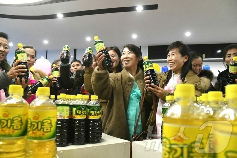 開城市開豊区域の地方工業工場で生産されたしょうゆを見ている北朝鮮住民＝労働新聞(c)news1