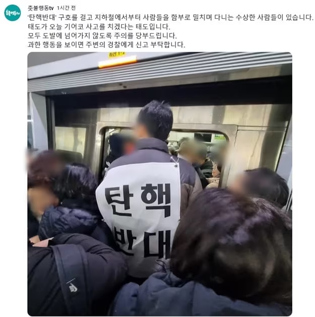 「弾劾反対」のプラカードを背負い、混雑する地下鉄に乗り込もうとする男性＝YouTubeより(c)news1