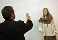 写真は、携帯カメラでショーに出演したモデルを撮影する男性。(c)AFP/BEHROUZ MEHRI