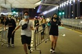 香港空港で、空港ターミナル入り口を封鎖するため防護柵を動かす民主派のデモ隊（2019年8月13日撮影）。(c)Manan VATSYAYANA / AFP