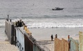 メキシコ・プラヤスデティフアナから見た、米国側の国境フェンスを補強する作業員と付近の警備に当たる米兵（2018年11月15日撮影）(c)ALFREDO ESTRELLA / AFP