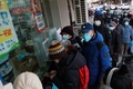 新型コロナウイルスの感染が急拡大する中、薬局に並ぶ人々。中国・江蘇省南京市で（2022年12月20日撮影）。(c)AFP