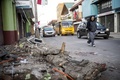 地震により被害を受けたチリ・イジャペルで、がれきの横を歩く男性（2015年9月17日撮影）。(c)AFP/MARTIN BERNETTI