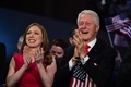 米ペンシルベニア州フィラデルフィアで開催中の民主党全国大会で、ヒラリー・クリントン前国務長官の米大統領選候補指名受諾演説に拍手する夫のビル・クリントン元大統領と娘のチェルシーさん（2016年7月28日撮影）。(c)AFP/Robyn BECK
