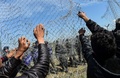 ギリシャ・イドメニの対マケドニア国境で起きたマケドニア警察と移民らとの衝突で、フェンスを破る移民や難民（2016年4月10日撮影）。(c)AFP/BULENT KILIC