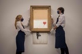 ロンドンの競売会社サザビーズ競売所で公開されたバンクシーの作品「Love is in the Bin（愛はごみ箱の中に）」（2021年9月3日撮影）。(c)Tolga Akmen / AFP