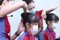 台湾・桃園にある中華航空の施設で行われたイベントで、客室乗務員たちに髪をセットしてもらう少女たち（2020年8月8日撮影）。(c)Sam Yeh / AFP