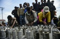マケドニアの兵士らに投げられた催涙弾の空き缶を示す難民や移民たち（2016年4月撮影）。(c)AFP/Bulent Kilic
