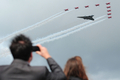 英南部のハンプシャー（Hampshire）で9日、ファンボロー国際航空ショー（Farnborough International Airshow）が開幕した。債務に苦しむ各国政府が軍事費を削減している中、今回のショーで発表される軍用機の大型契約は少ないとみられる。

写真は、デモ飛行する英空軍のアクロバットチーム、レッドアローズ（Red Arrows）とバルカン（Vulcan）爆撃機（2012年7月9日撮影）。(c)AFP/CARL COURT