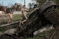 ウクライナ・ハルキウ市郊外に放置されたロシア軍の戦車T90Aを調べるウクライナ兵（2022年9月30日撮影）。(c)Yasuyoshi CHIBA / AFP