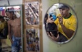 ブラジル・リオデジャネイロ（Rio de Janeiro）の理髪店で、男性客の後頭部にサッカー男子ブラジル代表のネイマール（Neymar da Silva Santos Junior）選手の肖像を施す理髪師（2014年6月27日撮影）。(c)AFP/YASUYOSHI CHIBA