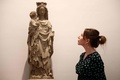 英ロンドンのコートールド美術館の「Art and Artifice: Fakes from the Collection（アートと策略：コレクションの贋作）」展で14世紀に作られたと見せ掛けた20世紀の彫刻作品を見る同館の職員（2023年6月16日撮影）。(c)HENRY NICHOLLS / AFP