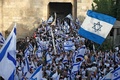 中東エルサレムで、イスラエル国旗を掲げて旧市街のダマスカス門をくぐるユダヤ人デモ隊（2022年5月29日撮影）。(c)Ahmad GHARABLI / AFP