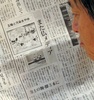 都内で、仏紙が掲載した風刺画について報じる日本の新聞記事を読む人（2013年9月12日撮影）。(c)AFP/KAZUHIRO NOGI
