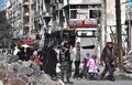 シリア・アレッポで、政府軍が反体制派から奪還した東部にある自宅に政府側部隊の監視のもと帰宅する住民たち（2016年12月8日撮影）。(c)AFP/GEORGE OURFALIAN