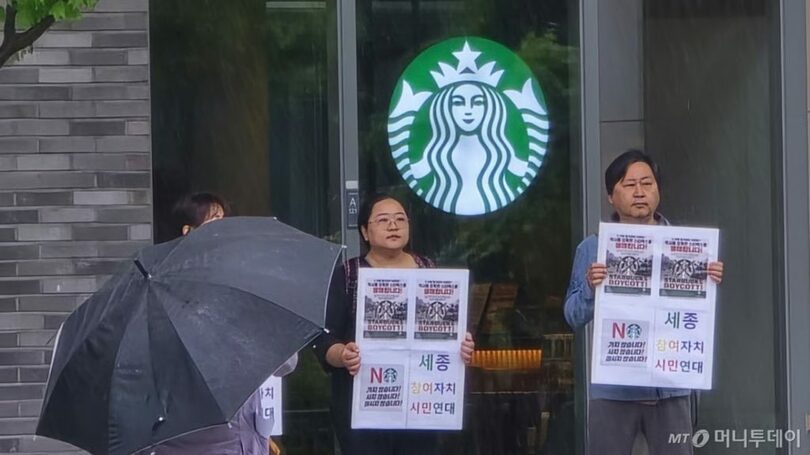 20日、世宗市ポラム洞のスターバックス・ポラム店前で、プラカードを掲げて抗議する世宗参与自治市民連帯の関係者ら(c)MONEYTODAY