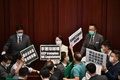 香港立法会で、中国政府による「国家安全法」の導入に反対し、プラカードを掲げる民主派の議員ら（2020年5月22日撮影）。(c)Anthony WALLACE / AFP