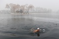 スモッグに覆われた中国・北京の湖で泳ぐ男性（2017年1月1日撮影）。(c)AFP/GREG BAKER