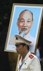ベトナム・ハノイ（Hanoi）で行われた軍事パレードを終え、ホー・チ・ミン（Ho Chi Minh）の肖像を持って会場を後にする警察官（2010年10月10日撮影）。(c)AFP/HOANG DINH Nam