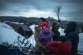 マケドニアの対セルビア国境の村近くにある仮設キャンプで、他の移民や難民と共にセルビア側への越境許可を待つ女性（2016年3月9日撮影）。(c)AFP/Robert ATANASOVSKI