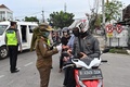 インドネシアのジャカルタで、外出制限が課される中、運転手の証明書を確認する警官ら（2020年5月11日撮影）。(c)ADEK BERRY / AFP