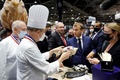 仏リヨンで開催された外食・ホテル業の見本市で食品を試食するエマニュエル・マクロン大統領（右から2人目、2021年9月27日撮影）。（c)Ludovic MARIN / POOL / AFP