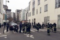 銃撃のあった仏パリ（Paris）にある風刺週刊紙シャルリー・エブド（Charlie Hebdo）の本社前に集まる警察官と消防隊員（2015年1月7日撮影）。(c)AFP/PHILIPPE DUPEYRAT
