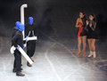 フィギュアスケート世界国別対抗戦（%%ISU World Team Trophy 2009%%）のエキシビションが19日、東京・国立代々木競技場で行われ、日本の安藤美姫（%%Miki Ando%%）や浅田真央（%%Mao Asada%%）が、ゲストとして登場した米パフォーマンス集団ブルーマングループ（%%Blue Man Group%%）とともにパフォーマンスした。写真はブルーマングループとパフォーマンスする安藤美姫（右）と浅田真央（右2）。（2009年4月19日）(c)AFP/TORU YAMANAKA
