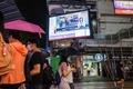 香港中心部で、中国の習近平国家主席の映った交差点にある大画面と歩行者（2020年5月21日撮影）。(c)Anthony WALLACE / AFP