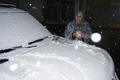 イラク首都バグダッドで、車の上に積もった雪を手に取る女性（2020年2月11日撮影）。(c)SABAH ARAR / AFP