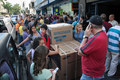 ベネズエラの首都カラカス（Caracas）市内にある家電販売店の前で長蛇の列を作る地元住民たち（2010年1月9日撮影）。(c)AFP/Carlos Ramirez