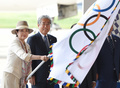 日本オリンピック委員会の竹田恒和会長（右）らとともに羽田空港で行われた歓迎式典に出席し、五輪旗を振る東京都の小池百合子知事（2016年8月24日撮影）。(c)AFP/TORU YAMANAKA