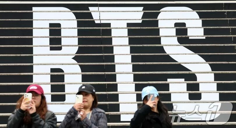 BTSカムバック公演広報物と記念撮影する外国人観光客(c)news1