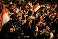 イラク・バグダッドのタハリール広場で、国旗を掲げて反政府デモに参加する人々（2019年10月24日撮影）。(c)AFP