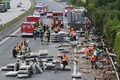 オーストリア北部リンツに近い高速道路で、トラックの積み荷が落下して逃げ出したニワトリを撤去する作業員ら（2017年7月4日撮影）。(c)AFP/APA / FOTOKERSCHI.AT/KERSCHBAUMMAYR