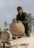 シリア北部アレッポ南郊で、バッシャール・アサド政権軍が反体制派から軍士官学校を奪還した後、戦車の上に立つシリア兵（2016年9月4日撮影）。(c)AFP/GEORGE OURFALIAN