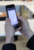 携帯電話で顔認証技術の使用を実演する、シンガポール政府技術庁のパートナー企業「トッパン・エカリア」のリー・シー・リン氏（2020年10月1日撮影）。(c)MARTIN ABBUGAO / AFP
