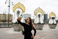 ロシア・モスクワのホテル「ラディソン・コレクション」前に設置されたマトリョーシカと写真を撮る女性（2021年9月9日撮影）。(c)Kirill KUDRYAVTSEV / AFP