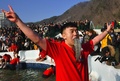韓国・江原道の華川で開かれたヤマメ祭りのつかみ取りでヤマメをくわえる男性（2019年1月5日撮影）。(c)Jung Yeon-je / AFP