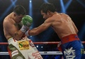 ボクシング、WBOインターナショナル・ウェルター級王者決定戦12回戦。ブランドン・リオス（Brandon Rios、左）にパンチを浴びせるマニー・パッキャオ（Manny Pacquiao、2013年11月24日撮影）。(c)AFP/Dale de la Rey