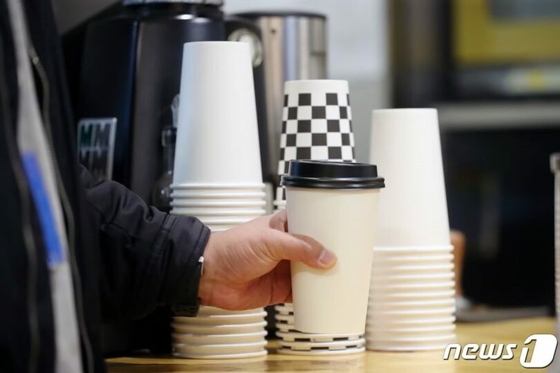 ソウル市内のカフェで、紙カップ入りの飲み物を持ち帰る客(c)news1